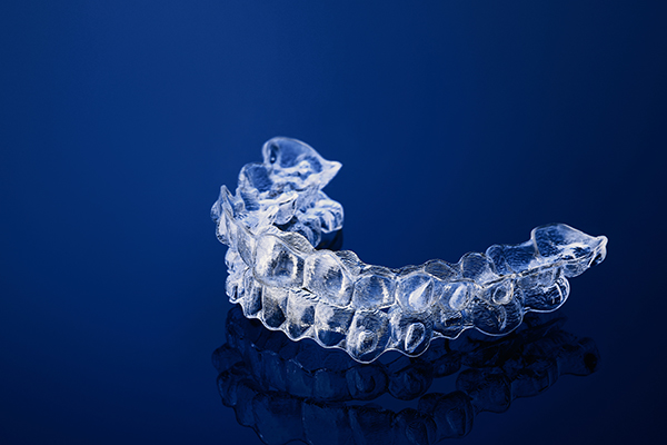 Invisible orthodontics cosmetic brackets on gradient background, tooth aligners, plastic braces. A way to have a beautiful smile and white teeth.